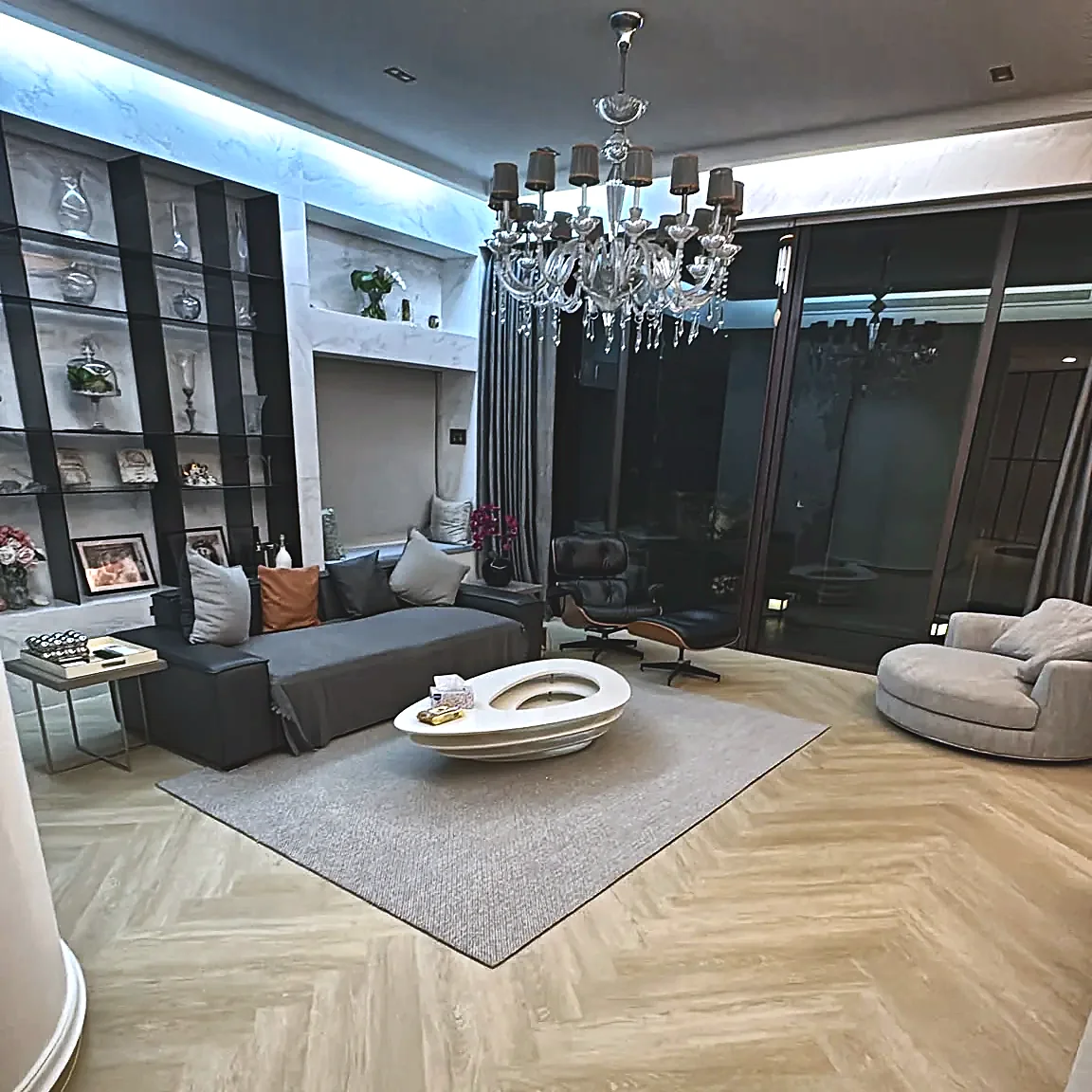 Living room renovation by Home Expo Asia with herringbone flooring and built-in display shelving